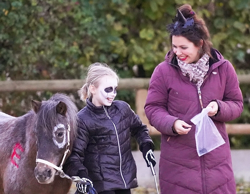 Christina Pavel mit Kindern in Halloween-Kostümen und einem Pony